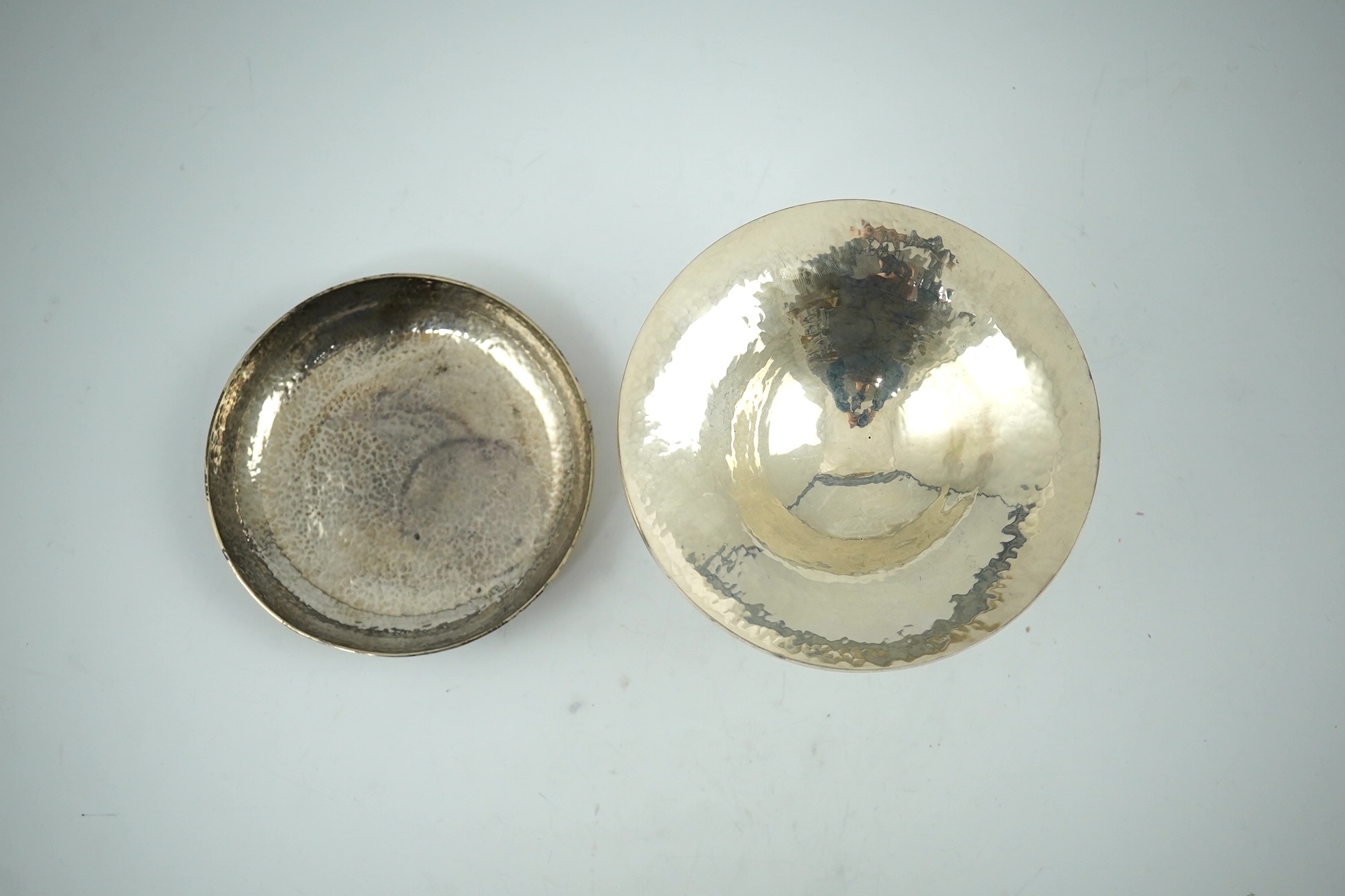 An Elizabeth II planished silver tazza, by Simone Genevieve Rutherford, on tripod supports, height 86mm and a similar planished shallow dish, London, 1997, 15.7oz. Condition - good